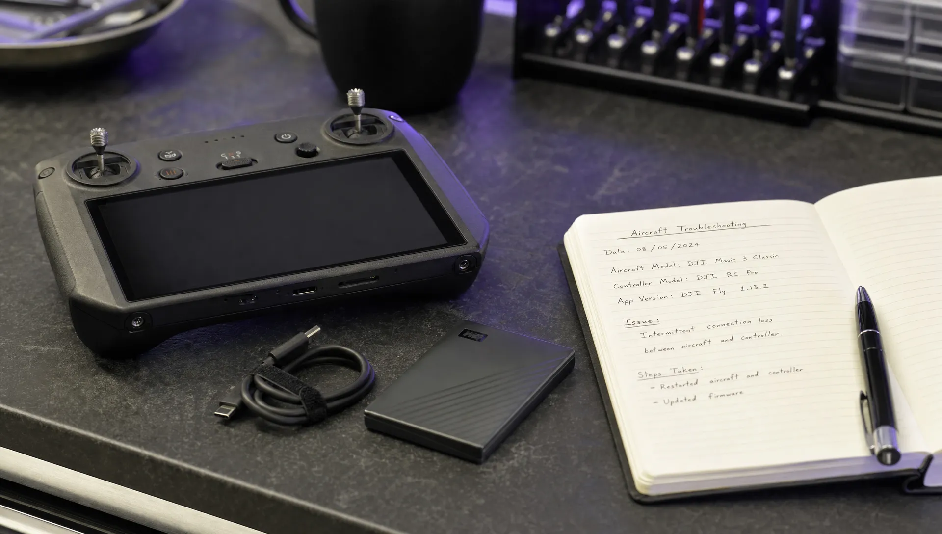 A remote controller, USB cable, backup drive and notebook are laid out for DJI log export troubleshooting.