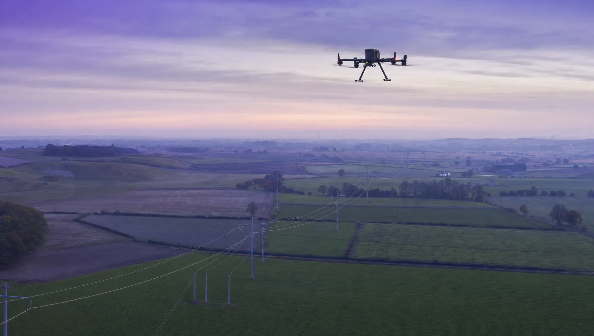 A DJI Matrice 350RTK flies over a rural electricity-line corridor during a drone line of sight waiver inspection.